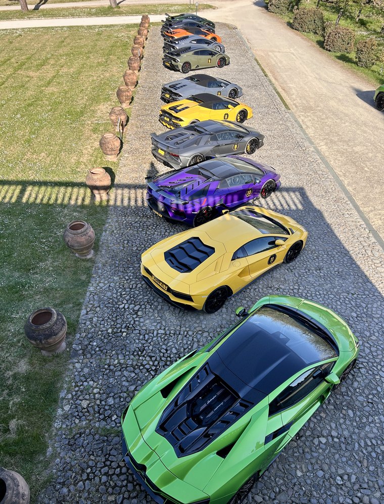 Line of supercars parked on Tuscan gravel
