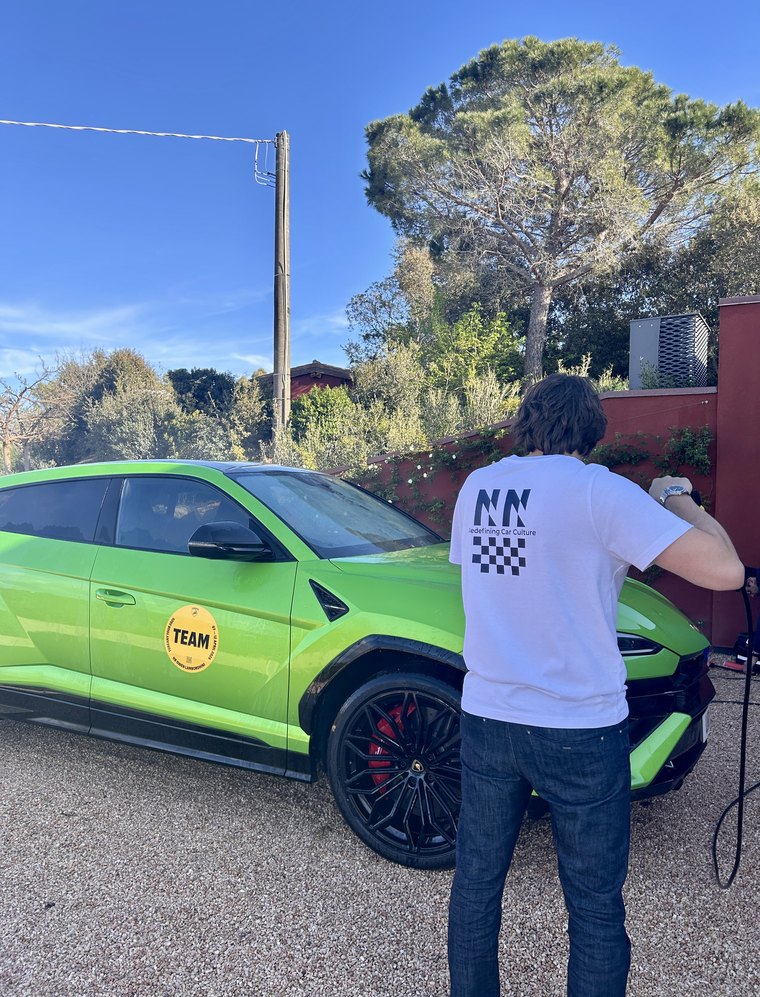 Team member preparing a green Lamborghini for a driving experience